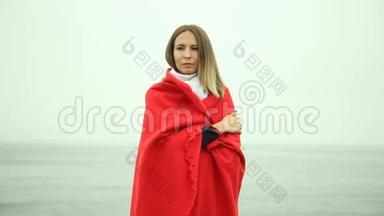 孤独悲伤的女孩，穿着<strong>红毯</strong>在海边